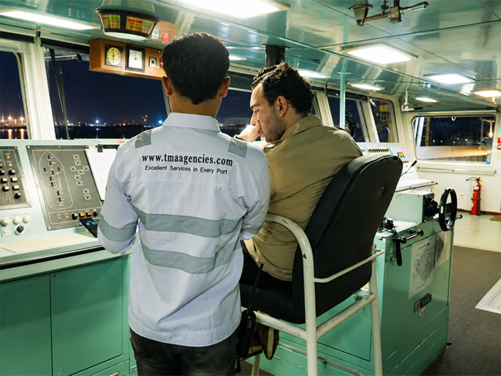 TMA Group shipping agency staff coordinating vessel operations with the ship's captain on the bridge before port arrival in Indonesia.